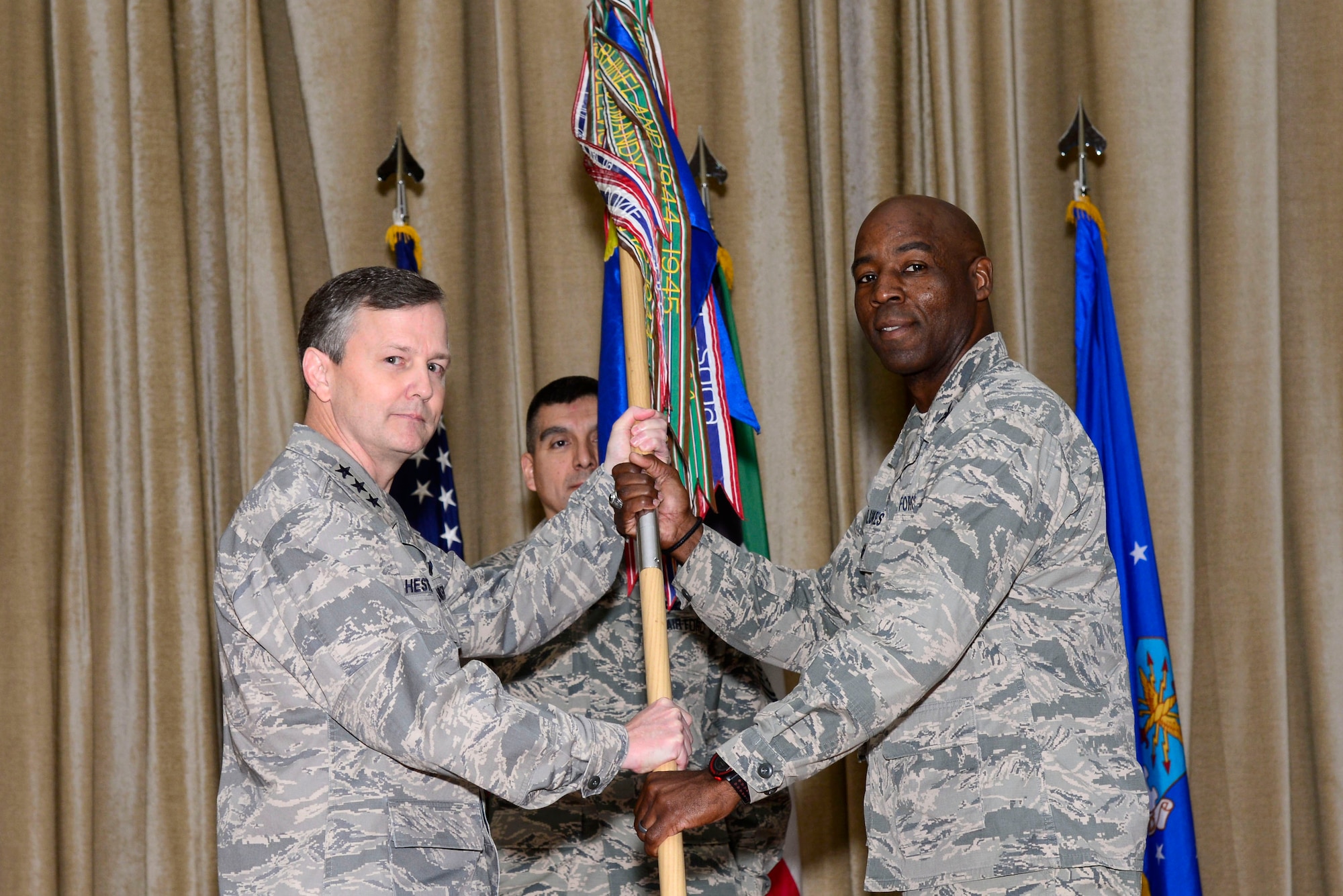 U.S. Air Force Lt. Gen. John Hesterman III, Commander of U.S. Air Forces Central Command, passes the guidon to Col. Clarence Lukes Jr., 386th Air Expeditionary Wing commander, during a change of command ceremony at an undisclosed location in Southwest Asia, June 15, 2015. Lukes assumed command after serving as the 374th Airlift Wing vice commander at Yokota Air Base, Japan. (U.S. Air Force photo by Senior Airman Racheal E. Watson)