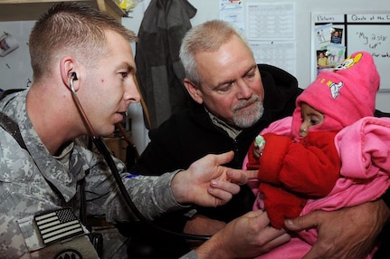 Army Capt. Regan Norgaard, 196th Maneuver Enhancement Brigade, South Dakota 
National Guard, listens to Asma's heart on Jan. 2, 2011, at Camp Phoenix in 
Kabul, Afghanistan as Mr. Jim O'Neil looks on. Norgaard was able to assess her 
condition before being able to fly to America to receive a life-saving heart 
surgery.