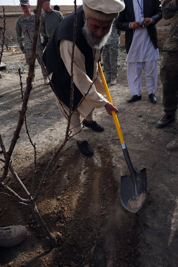 Engineer Lali Zadran, Paktya director of agriculture and irrigation, plants a tree at Forward Operating Base Gardez during an Afghan New Year celebration, March 27, 2011. The trees were donated by the Oklahoma National Guard's 2-45th Agribusiness Development Team as a symbol of growth in the province.