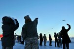 Members of the Alaska Air National Guard's 176th Wing watch as the Wing's aircraft fly over the base, Feb. 12, 2011. Eleven aircraft from the 176th were flown from Kulis to Joint Base Elmendorf-Richardson during a ceremonial flight.