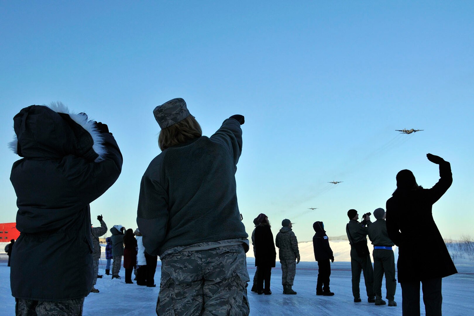 Members of the Alaska Air National Guard's 176th Wing watch as the Wing's aircraft fly over the base, Feb. 12, 2011. Eleven aircraft from the 176th were flown from Kulis to Joint Base Elmendorf-Richardson during a ceremonial flight.