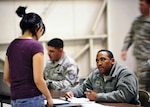 Senior Airman Kenya Capers, 460th Force Support Squadron, helps a Department
of Defense family member through in-processing March, 24, 2011. Operation
Pacific Passage was a joint service tasking that came together to facilitate
the needs of the many family members who would arrive at the airport.