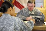 Spc. David Street with the 1153rd Financial Management Detachment assists a
customer at the Camp Liberty Finance Office on Camp Liberty, Iraq, March 21,
2011. The 1153rd FMD, a Florida Army National Guard unit, covers a
split-operations mission at Victory Base Complex - which includes Camp
Liberty - and Forward Operating Base Union III. By fulfilling its most
critical role of resolving service members' pay problems, the detachment
helps ensure Soldiers stay mission-focused. (U.S. Army photo by Sgt.
Jennifer Sardam)