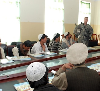 Army Spc. Jack McComas, a project manager for the 2-45th Agribusiness Development Team, talks to farmers from the Dand Patan district, March 13, 2011. McComas, one of the ADT’s specialists in animal husbandry, talked to the farmers about how to properly care for a variety of animals.