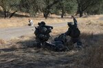 Scouts with the California National Guard's 1st Battalion, 184th Infantry Regiment, blow out of a notional surveillance site to break contact with enemy "guerrillas" from the 578th Brigade Engineer Battalion on June 11, 2015, during their two-week annual training period at Camp Roberts, Calif.