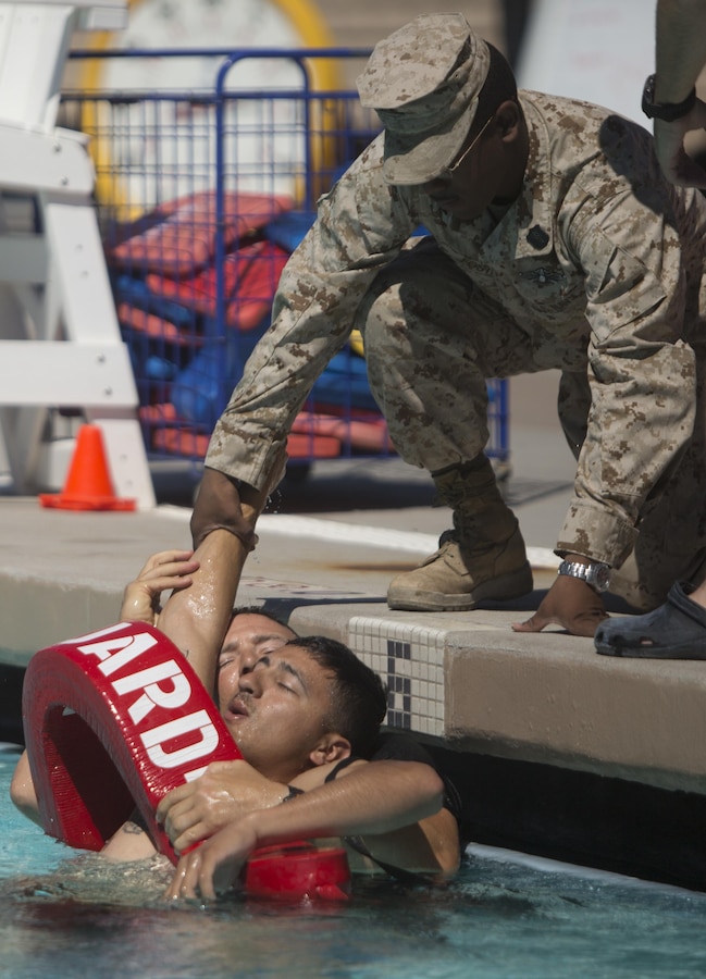Petty Officer 2nd Class Vonterrias Foster, a Fleet Marine Force hospital corpsman with Bravo Company, 4th Reconnaissance Battalion, 4th Marine Division, Marine Forces Reserve, pulls a swim casualty from the pool in a demonstration of safety procedures before a reconnaissance assessment at the Combat Center Training Tank at Marine Corps Air Ground Combat Center Twentynine Palms, Calif., June 16, 2015. Marines must pass the swim intensive assessment in order to be accepted into the Basic Reconnaissance Course. (U.S. Marine Corps photo by Cpl. Ian Leones/Released)