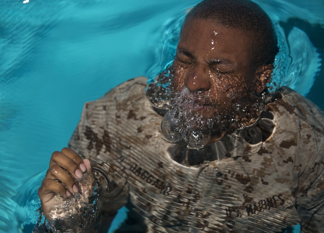 Lance Cpl. Brandon A. Jaggard, a machine gunner with Bravo Company, 4th Reconnaissance Battalion, 4th Marine Division, Marine Forces Reserve, emerges from the water during the Reconnaissance Assessment at the Combat Center Training Tank at Marine Corps Air Ground Combat Center Twentynine Palms, Calif., June 16, 2015. Marines must pass all portions of the assessment in order to attend the Basic Reconnaissance Course, which focuses on the doctrines of amphibious reconnaissance. (U.S. Marine Corps photo by Cpl. Ian Leones/Released)
