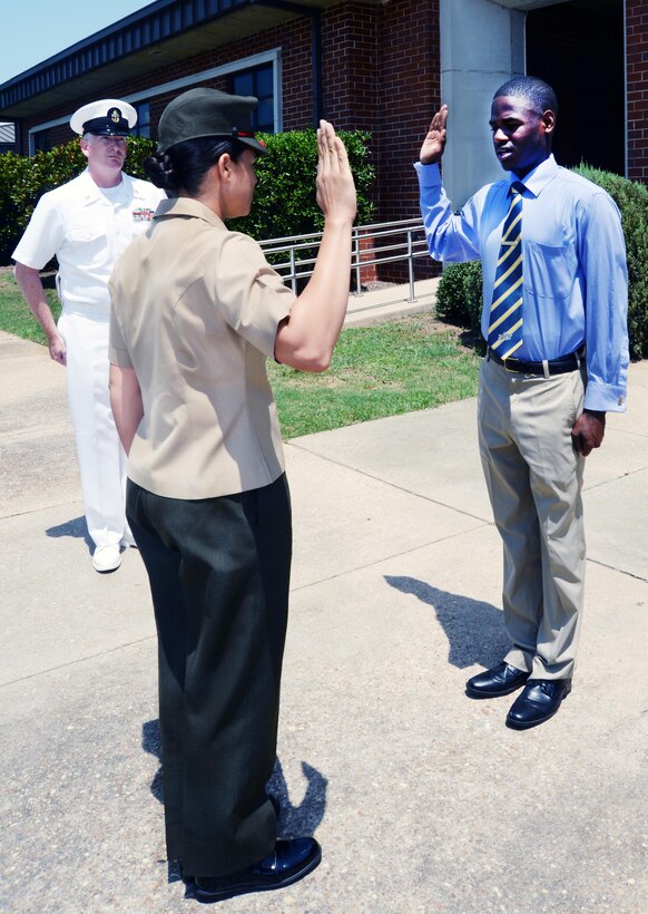 Jawaun Stanley, a Lee County High School graduate, recites an oath of enlistment as a midshipman in the Navy Reserves in front of Marine Corps Logistics Base Albany's Coffman Hall, June 17. Capt. Rene Barber, project manager, Marine Corps Systems Command-Albany, rendered the oath to the 18-year-old in front of his parents, Marines, Navy recruiters and civilian-Marines. Stanley will attend the Naval Academy Preparatory School in Rhode Island before attending the U.S. Naval Academy in Annapolis, Md.