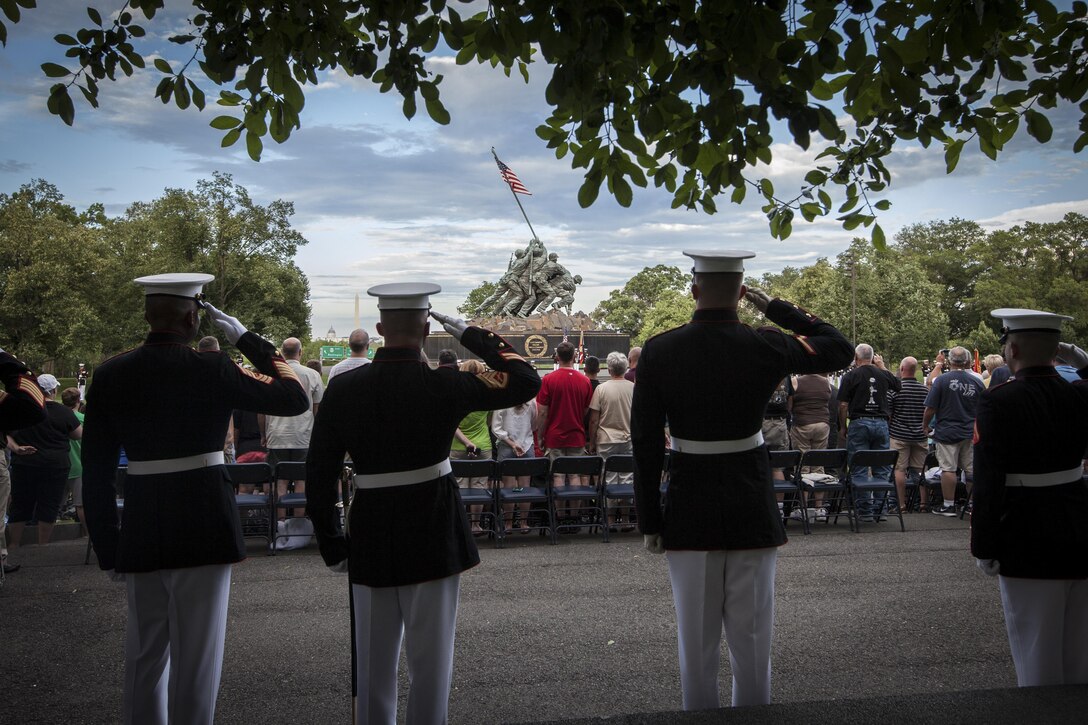 U.S. Marine render honors during the presentation of the Colors during a sunset parade at the Marine Corps War Memorial, Arlington, Va., June 16, 2015. The Honorable Stephen A. Womack, congressman, R-Ark., was the guest of honor for the parade and Lt. Gen. William M. Faulkner, deputy commandant, Installations and Logistics Command, was the hosting official for that same parade. Since September 1956, marching and musical units from Marine Barracks Washington, D.C., have been paying tribute to those who’s “Uncommon valor was a common virtue” by presenting sunset parades in the shadow of the 32-foot high figures of the United States Marine Corps War Memorial. (U.S. Marine Corps photo by Sgt. Melissa Marnell/Released)
