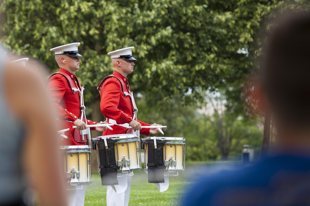 U.S. Marines with the Marine Corps Drum and Bugle Corps perform during the sunset parade at the Marine Corps War Memorial, Arlington, Va., June 16, 2015. The Honorable Stephen A. Womack, congressman, R-Ark., was the guest of honor for the parade, and U.S. Marine Corps Lt. Gen. William M. Faulkner, deputy commandant, Installations and Logistics command, was the hosting official. Since September 1956, marching and musical units from Marine Barracks Washington, D.C., have been paying tribute to those who’s “Uncommon valor was a common virtue” by presenting sunset parades in the shadow of the 32-foot high figures of the United States Marine Corps War Memorial. (U.S. Marine Corps photo by Lance Cpl. Alejandro Sierras/ Released)
