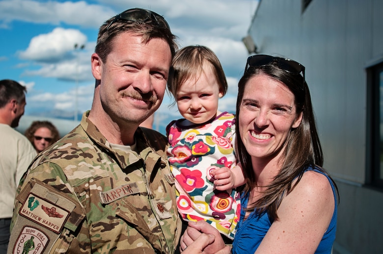 Alaska Air National Guardsman Maj. Matthew Harper, with the 210th Rescue Squadron, poses for a photo with his family at Joint Base Elmendorf-Richardson, June 12. Harper, along with 15 additional Guardsmen from the 176th Operations Group, the 210th Rescue Squadron, the 211th Rescue Squadron and the 176th Logistics Readiness Squadron, returned from a four month deployment to Djibouti in support of Operation Enduring Freedom. (Air National Guard photo by Staff Sgt. Edward Eagerton/released)