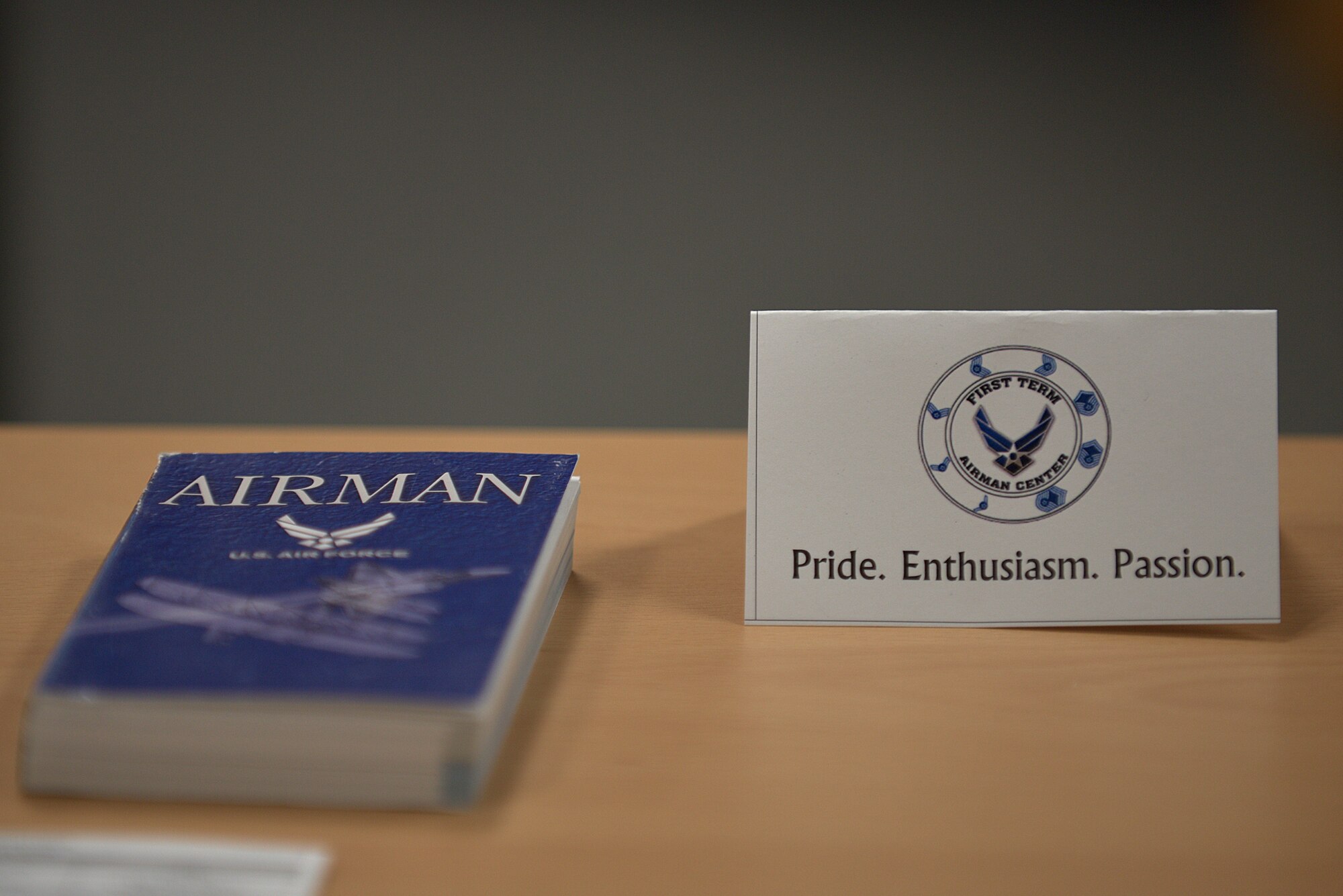 The First Term Airman Center emblem and motto is displayed on a desk at Misawa Air Base, Japan, June 1, 2015. The motto of pride, enthusiasm and passion is one that Master Sgt. Daniel Robinson, 35th Fighter Wing career assistance advisor, takes to heart and uses as a foundation for mentoring others. (U.S. Air Force photo by Senior Airman Jose L. Hernandez-Domitilo)