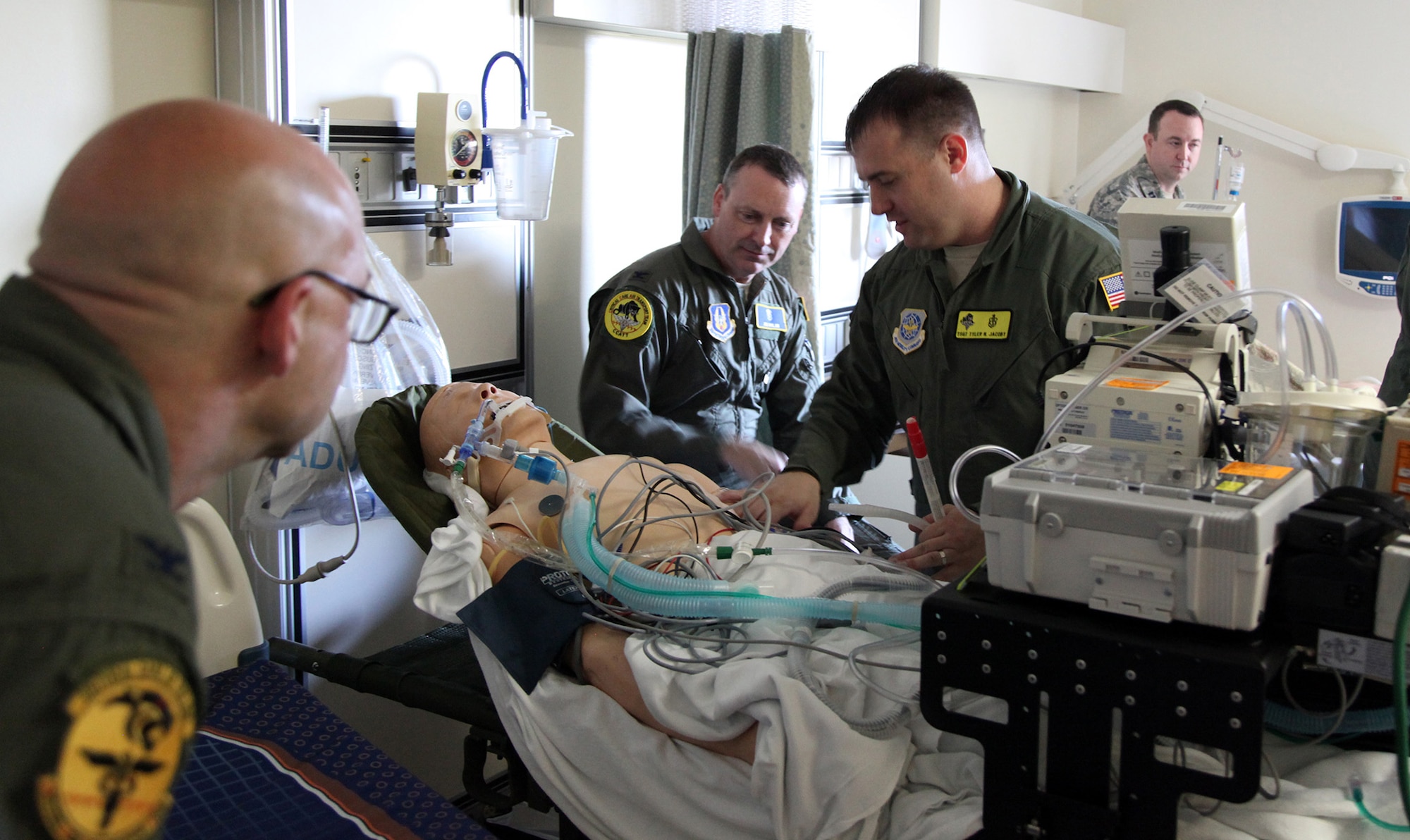 TRAVIS AIR FORCE BASE, Calif. -- Col. (Dr.) Scott Vandehoef (left), 60th Medical Operations Squadron Emergency Services Flight commander, Col. (Dr.) James Dolan, a surgeon with the 349th Aeromedical Staging Squadron, and Tech. Sgt. Tyler Jacoby, a cardiopulmonary technician with the 60th Surgical Operations Squadron, prepare to practice transporting a simulated critically ill patient as part of a critical care air transport team during 349th Air Mobility Wing Air Force Specialty Code training June 6, 2015, at David Grant USAF Medcial Center, Travis Air Force Base, California.  In preparation for the training, the 349th Aeromedical Evacuation Squadron transformed the four-engine tactical transport into a flying hospital. In turn, the CCATT teams from the 60th Surgical Operations Squadron and the 349th Aeromedical Staging Squadron established onboard what was essentially a portable intensive care unit dedicated to one very ill, simulated, "patient."  (U.S. Air Force photo/Lt. Col. Robert Couse- Baker/Released)