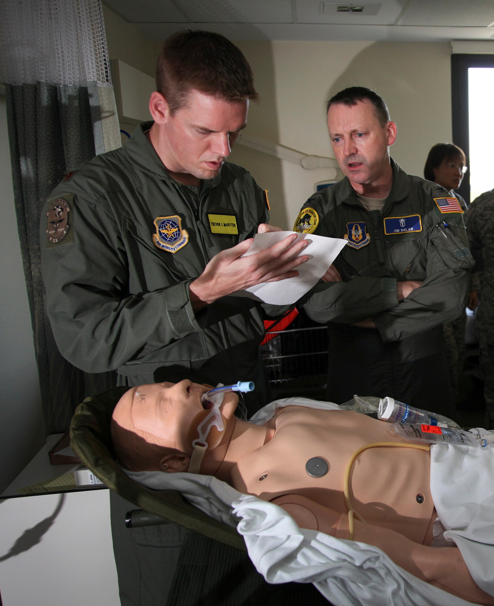 TRAVIS AIR FORCE BASE, Calif. -- Maj. (Dr.) Trevor McCotter (left), 60th Medical Operations Squadron, and  Col. (Dr.) James Dolan, a surgeon with the 349th Aeromedical Staging Squadron, prepare to practice transporting a simulated critically ill patient as part of a critical care air transport team during 349th Air Mobility Wing Air Force Specialty Code training June 6, 2015, at David Grant USAF Medcial Center, Travis Air Force Base, California. In preparation for the training, the 349th Aeromedical Evacuation Squadron transformed the four-engine tactical transport into a flying hospital. In turn, the CCATT teams from the 60th Surgical Operations Squadron and the 349th Aeromedical Staging Squadron established onboard what was essentially a portable intensive care unit dedicated to one very ill, simulated, "patient."  (U.S. Air Force photo/Lt. Col. Robert Couse- Baker/Released)