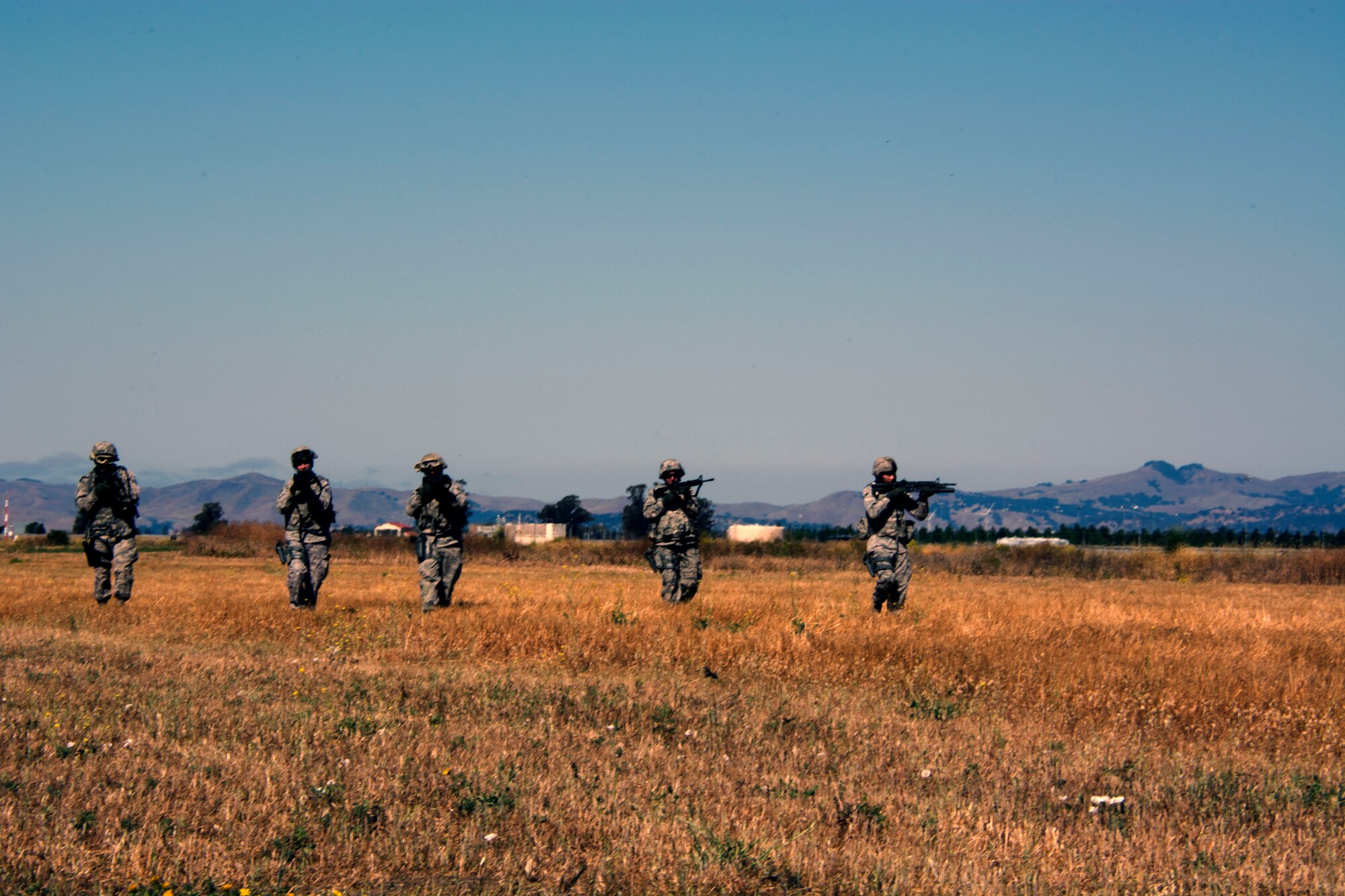 TRAVIS AIR FORCE BASE, Calif. -- A fire team of defenders from the 349th Security Forces Squadron sweep the surrounding area for enemy combatants June 7, 2015 at Travis Air Force Base, California. More than 40 defenders took part in a various expeditionary combat skills training scenarios during the Air Force Specialty Code weekend. (U.S. Air Force photo/ Staff Sgt. Christopher Carranza)