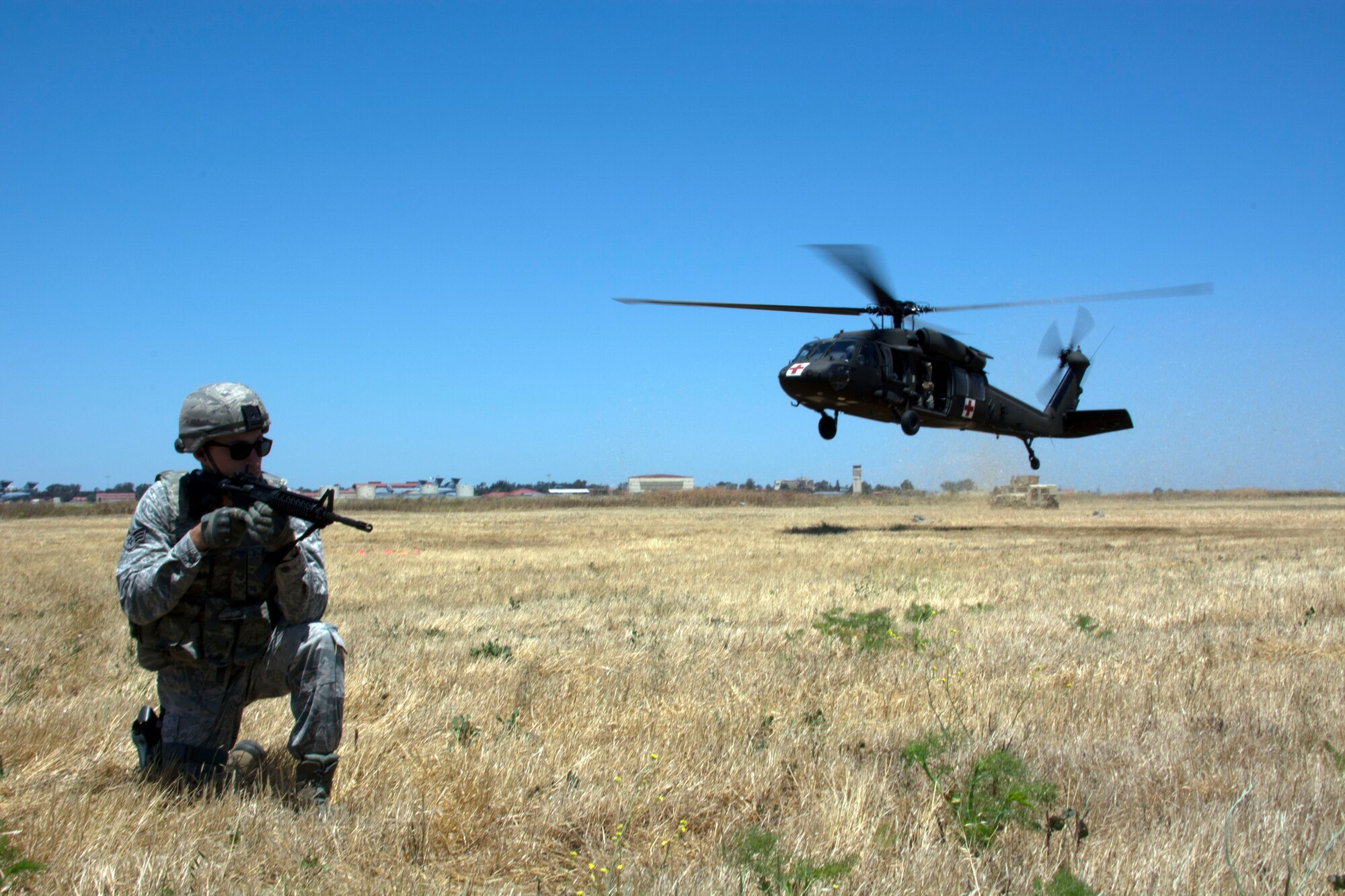 TRAVIS AIR FORCE BASE, Calif. -- Senior Airman Christopher Whalen, 349th Security Forces Squadron, defends the landing zone as a California Army National Guard UH-60 Black Hawk helicopter lands for a simulated blood transferJune 6, 2015 at Travis Air Force Base, California.More than 40 defenders took part in a various expeditionary combat skills training scenarios during the Air Force Specialty Code weekend. (U.S. Air Force photo/ Staff Sgt. Christopher Carranza)