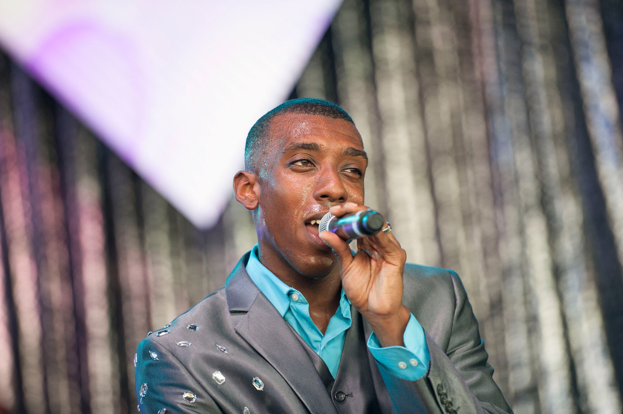 U.S. Air Force Airman 1st Class Rashaun Carter, Tops in Blue vocalist, sings during a performance June 12, 2015, at Wild Adventures in Valdosta, Ga. Carter is an aircrew flight equipment journeyman with the 58th Operations Support Squadron at Kirtland Air Force Base, N.M. (U.S. Air Force photo by Andrea Jenkins/Released)

