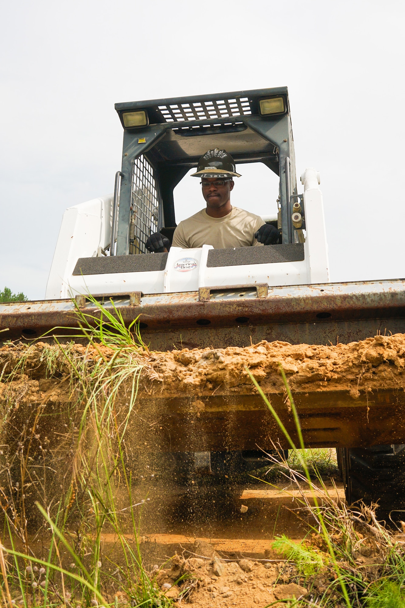 U.S. Air Force Senior Airman Ramirez Edmond, a cable and antenna systems specialist with the 202nd Engineering Installation Squadron (EIS), Georgia Air National Guard, removes dirt from a berm using a Bobcat during a weeklong training exercise at Robins Air Force Base, Ga., June 11, 2015. More than 80 Airmen were certified in career-field tasks crucial to the unit’s deployed and homeland missions. The 202nd EIS supports the 116th Air Control Wing and is responsible for the fixed-communications infrastructures for 27 other locations, including the 165th Airlift Wing in Savannah, Georgia, and Air National Guard units in Puerto Rico and the U.S. Virgin Islands. (U.S. Air National Guard photo by Senior Master Sgt. Roger Parsons/Released)