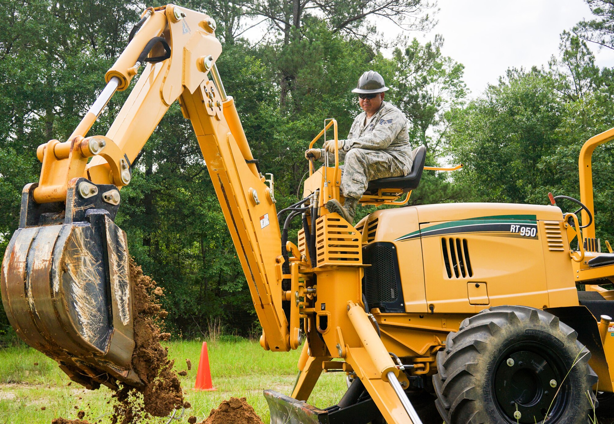 U.S. Air Force Staff Sgt. Chymann Lao, a cable and antenna systems specialist with the 202nd Engineering Installation Squadron (EIS), Georgia Air National Guard, digs a trench using a trencher with a backhoe attachment during a weeklong training exercise at Robins Air Force Base, Ga., June 11, 2015. More than 80 Airmen were certified in career-field tasks crucial to the unit’s deployed and homeland missions. The 202nd EIS supports the 116th Air Control Wing and is responsible for the fixed-communications infrastructures for 27 other locations, including the 165th Airlift Wing in Savannah, Georgia, and Air National Guard units in Puerto Rico and the U.S. Virgin Islands. (U.S. Air National Guard photo by Senior Master Sgt. Roger Parsons/Released)