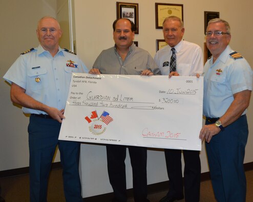 June 10, Canadian Forces officials from Continental North American Aerospace Defense  Command Region-1st Air Force ( Air Forces Northern) joined officials from the Guardian ad Litem  organization in Panama City to present a donation raised during the annual  CAN-AM 2015 Golf Tournament. (From Left) is  LCol. Larry Weir, Director, Assessments, Lessons Learned and Exercises Directorate (A9), Continental North American Aerospace Defense  Command Region-1st Air Force ( Air Forces Northern),  Fred Hapner, Director, 14th Judicial Circuit Guardian ad Litem, Jim Barr, 14th Judicial Circuit Guardian ad Litem Board President and  Maj. Trent Morrisey,  from A9. (Air Force photo released/Photo by Mary McHale)