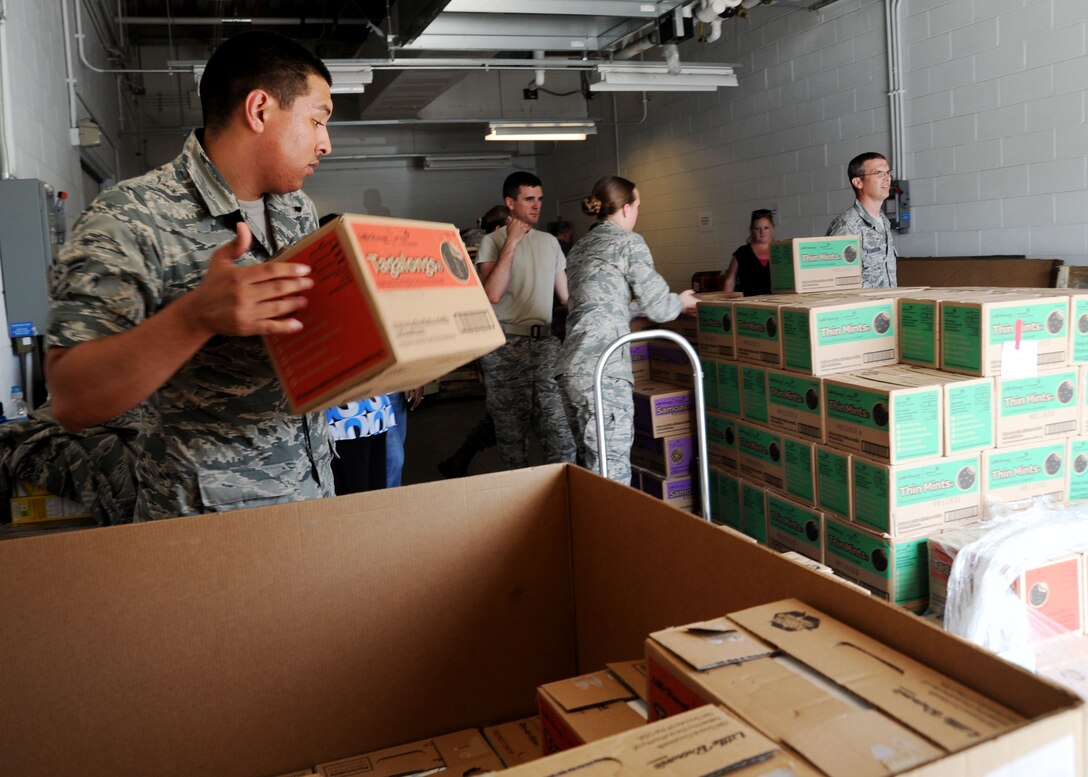 Airman 1st Class Miguel Davila, 779th Medical Support Squadron medical logistics technician, carries a case of Girl Scout Cookies to a pallet during Operation Cookie Drop at Joint Base Andrews, Md., June 16, 2015. This case and hundreds of others were donated to service members and their families by Girl Scouts Troops for Operation Cookie Drop/Girl Scouts Heart of the Hudson Council. Last year over 90,000 boxes of cookies were donated to service members around the world. (U.S. Air Force photo/ Staff Sgt. Nichelle Anderson) 
