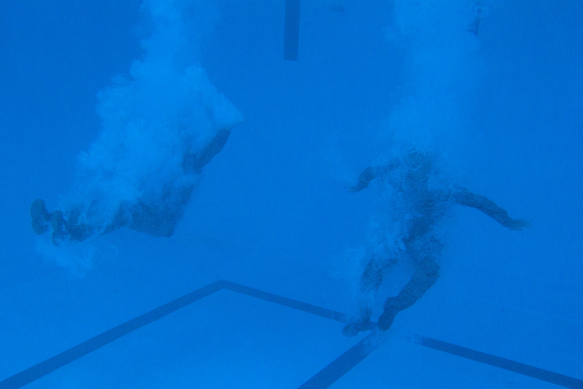 Two U.S. Marines successfully complete a pencil dive as part of the intermediate course of USMC Water Survival Training, June 10, 2015, at Camp Lejeune, North Carolina. Marines must successfully complete the intermediate course every three years to remain certified. (U.S. Air Force photo/Senior Airman Brittain Crolley)
