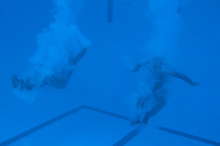 Two U.S. Marines successfully complete a pencil dive as part of the intermediate course of USMC Water Survival Training, June 10, 2015, at Camp Lejeune, North Carolina. Marines must successfully complete the intermediate course every three years to remain certified. (U.S. Air Force photo/Senior Airman Brittain Crolley)