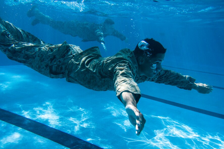 U.S. Marine Cpl. Mario Montanezroman, 3rd Battalion, 8th Marine Regiment, swims under water after completing a pencil dive as part of the intermediate course of USMC Water Survival Training, June 10, 2015, at Camp Lejeune, North Carolina. The scenario simulates having to abandon ship and swimming away from the wreckage for safety.  (U.S. Air Force photo/Senior Airman Brittain Crolley)
