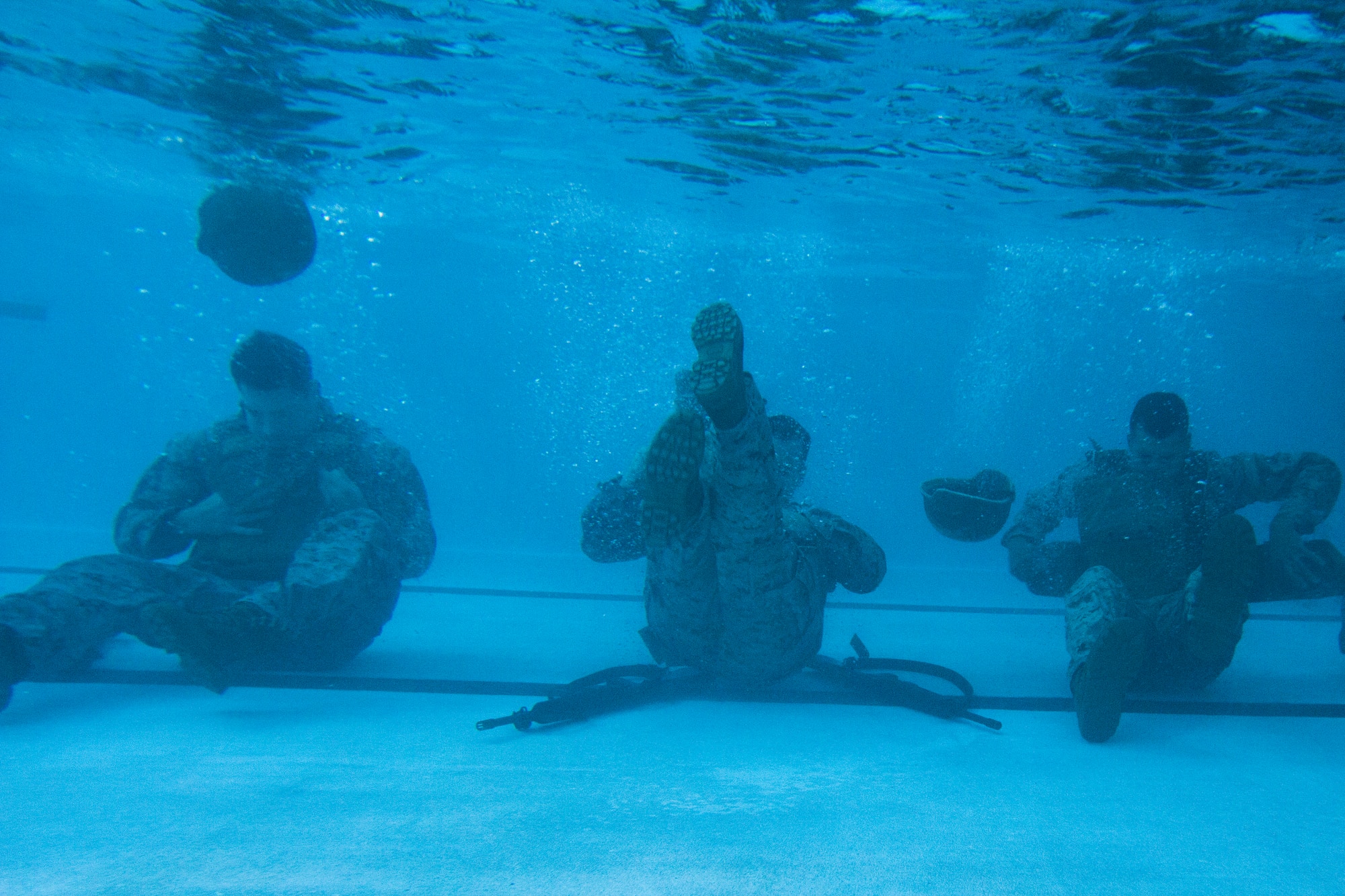 U.S. Marines from the 3rd Battalion, 8th Marine Regiment, shed their gear as part of the basic course of USMC Water Survival Training, June 10, 2015, at Camp Lejeune, North Carolina. Marines were given 10 seconds to fully submerse themselves and shed their helmet, flak jacket and rifle. (U.S. Air Force photo/Senior Airman Brittain Crolley)