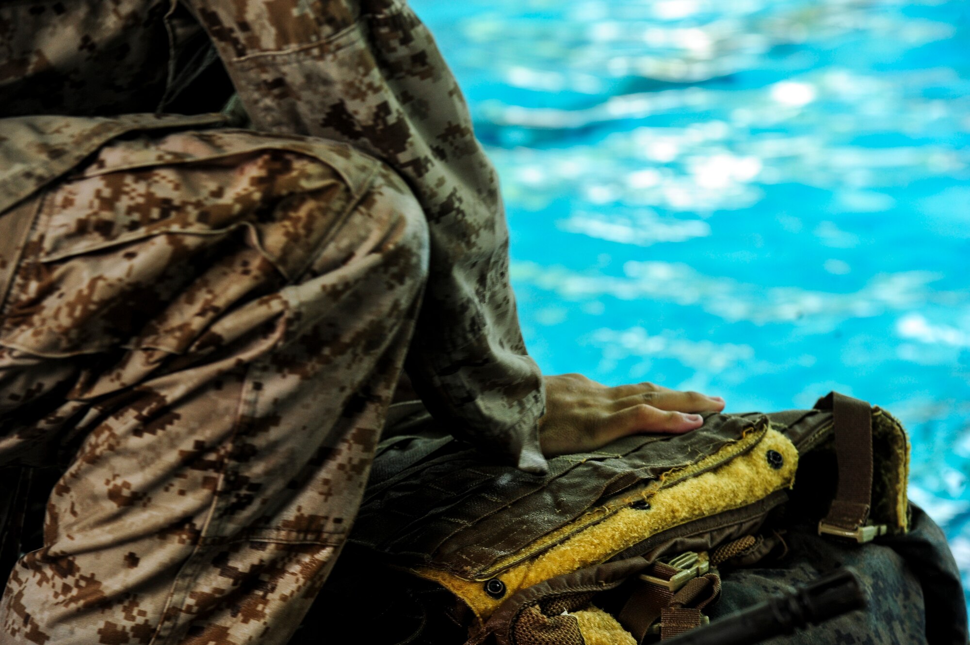 A U.S. Marine from the 3rd Battalion, 8th Marine Regiment, packs his equipment to use as a flotation device during the intermediate course of USMC Water Survival Training, June 10, 2015, at Camp Lejeune, North Carolina. Once the equipment was bundled together, Marines had to transfer it from one side of the pool to the other while maintaining positive control of all pieces. (U.S. Air Force photo/Senior Airman Brittain Crolley)
