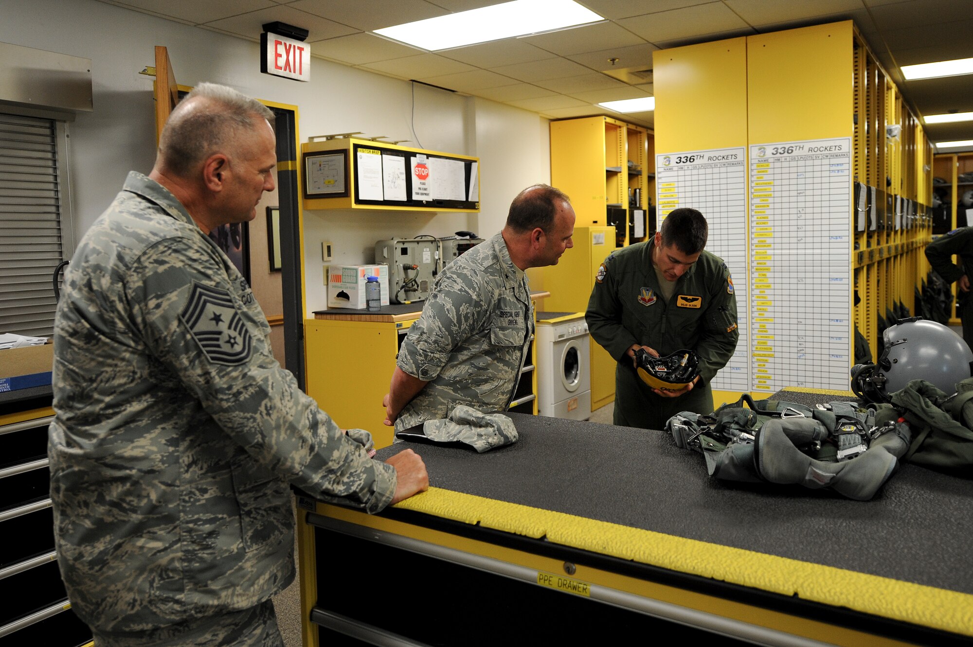 Capt. Andrew Olson, 336th Fighter Squadron pilot, shows Brig. Gen. Keith Givens, Air Force Office of Special Investigation commander, and Chief Master Sgt. Walker Cottingham, AFOSI command chief, a Joint Helmet Mounted Cueing System used by F-15E Strike Eagle pilots, during a squadron tour, June 11, 2015, at Seymour Johnson Air Force Base, North Carolina. The JHMCS allows pilots to aim sensors and weapons wherever they’re looking while monitoring flight data. (U.S. Air Force photo/Airman 1st Class Aaron J. Jenne)