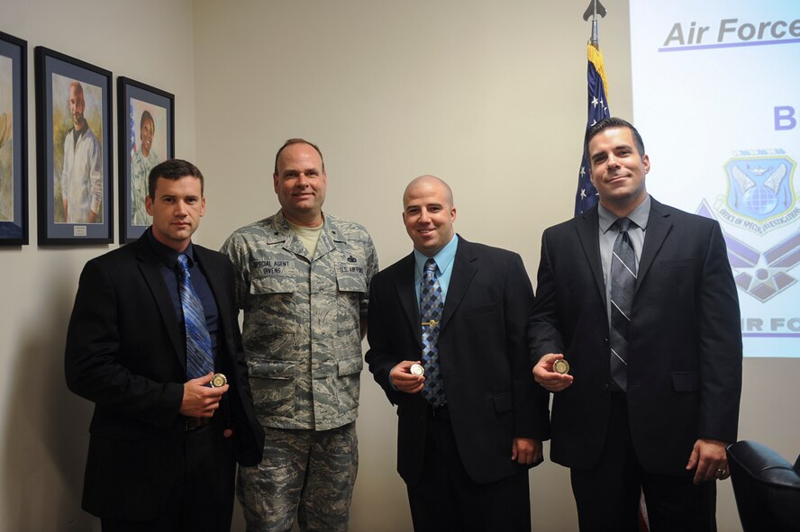 U.S. Air Force Brig. Gen. Kevin Givens, Air Force Office of Special Investigations commander, poses for a photo with Special Agents Jacob Frank, Maynard Depew and Michael Showers during his visit June 16, 2015, at Moody Air Force Base, Ga. Givens coined the three agents for their hard work and dedication to the mission. (U.S. Air Force photo by Senior Airman Olivia Bumpers/Released)