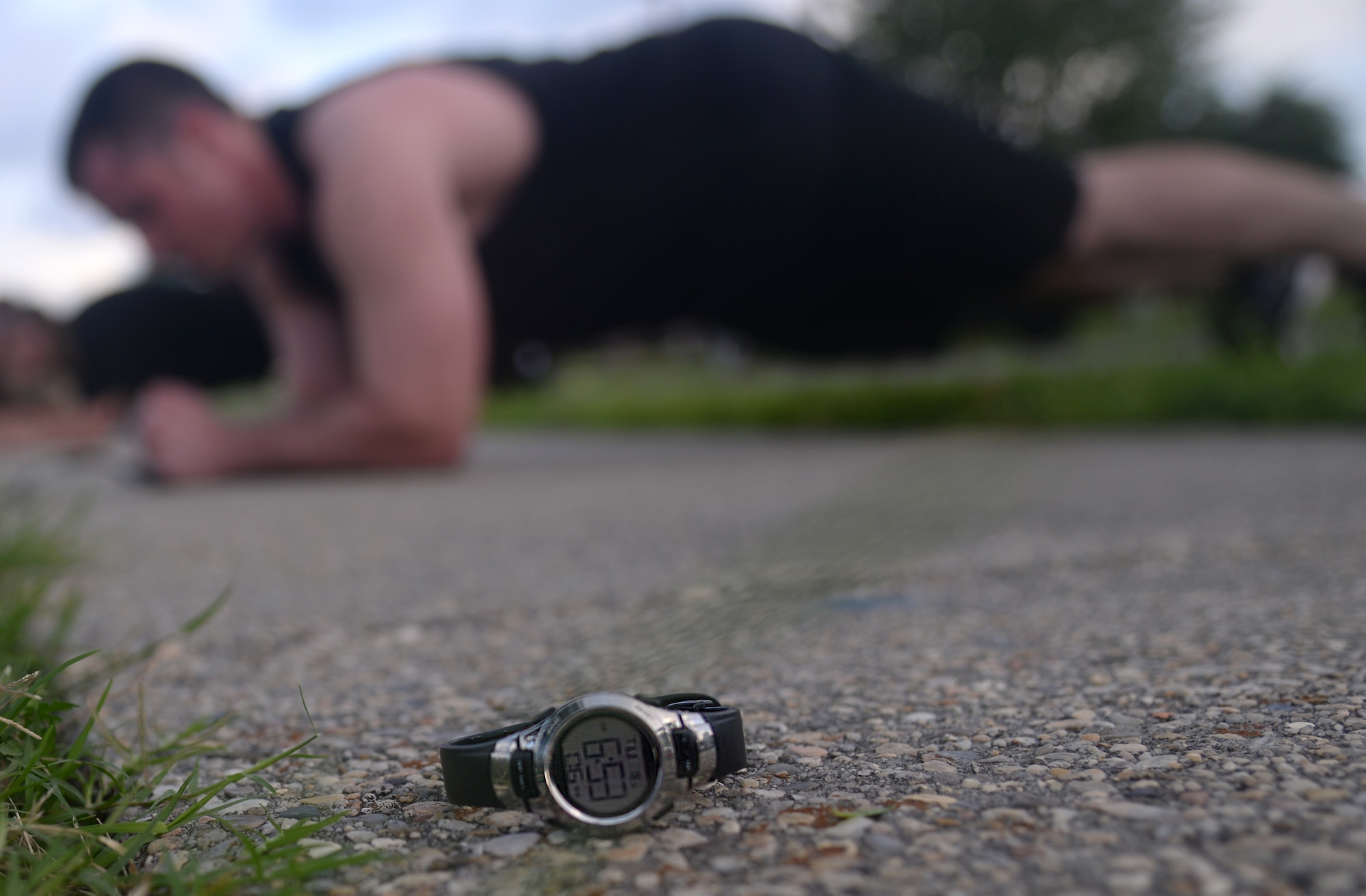 Senior Airman Chimer Clark III, 81st Comptroller Squadron customer service lead, performs a plank as an Airman’s watch lays on the ground timing a minute of planks at physical training, June 16, 2015, Keesler Air Force Base, Miss. The 81st CPTS conducts PT three times a week to build physical strength and foster squadron unity. (U.S. Air Force photo by Senior Airman Holly Mansfield)