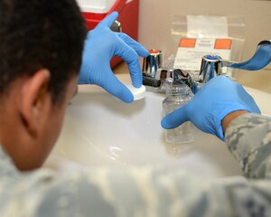 U.S. Air Force Airman Alex McClendon, 633rd Aerospace Medicine Squadron bioenvironmental engineering technician, samples tap water in the education center at Langley Air Force Base, Va., June 12, 2015. After sampling the water, McClendon checks water to ensure it meets the drinkable standard of between 7.2 and 8 on the pH scale and less than one percent of the water is chlorinated. (U.S. Air Force photo by Airman 1st Class Devin S. Michaels/Released)
