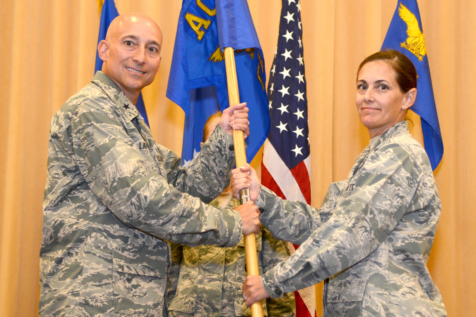 U.S. Air Force Col. Jennifer Kilborn, Air Combat Command civil engineering chief, passes the organization's guidon to Brig. Gen. Kenneth Lapierre, Air Combat Command Logistics, Engineering and Force Protection director, during the ACC Installations and Mission Support Directorate’s inactivation ceremony at Langley Air Force Base, Va., June 16, 2015. Air Combat Command’s civil engineering will now fall under the Logistics, Engineering and Force Protection Directorate. While active, the ACC Installations and Missions Support Directorate provided enterprise-wide housing solutions and conducted the strategic acquisition, management and disposal of Air Force real property. (U.S. Air Force photo by Airman 1st Class Devin S. Michaels/Released)