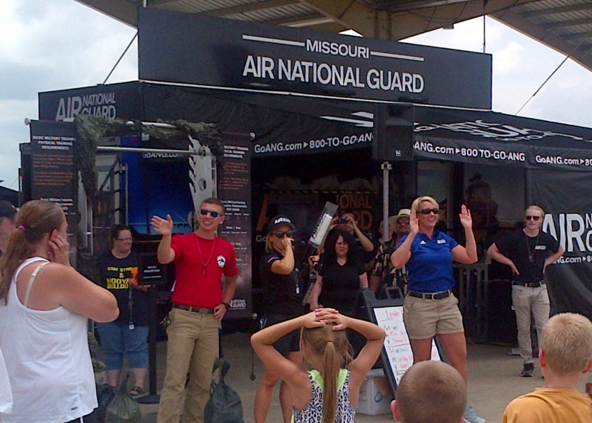 Airman 1st Class Albert Fleer (red shirt), aerospace ground equipment technician from the 131st Maintenance Squadron, and Master Sgt. Melissa Lakin, 131st Bomb Wing recruiting supervisor, get a large crowd pumped up at the Missouri Air National Guard recruiting trailer at the Wings Over Whiteman air show here June 13, 2015.  A number of Citizen-Airmen from the wing were on hand to support the two-day air show event.  (U.S. Air National Guard photo by Capt. Jeffrey Bishop)