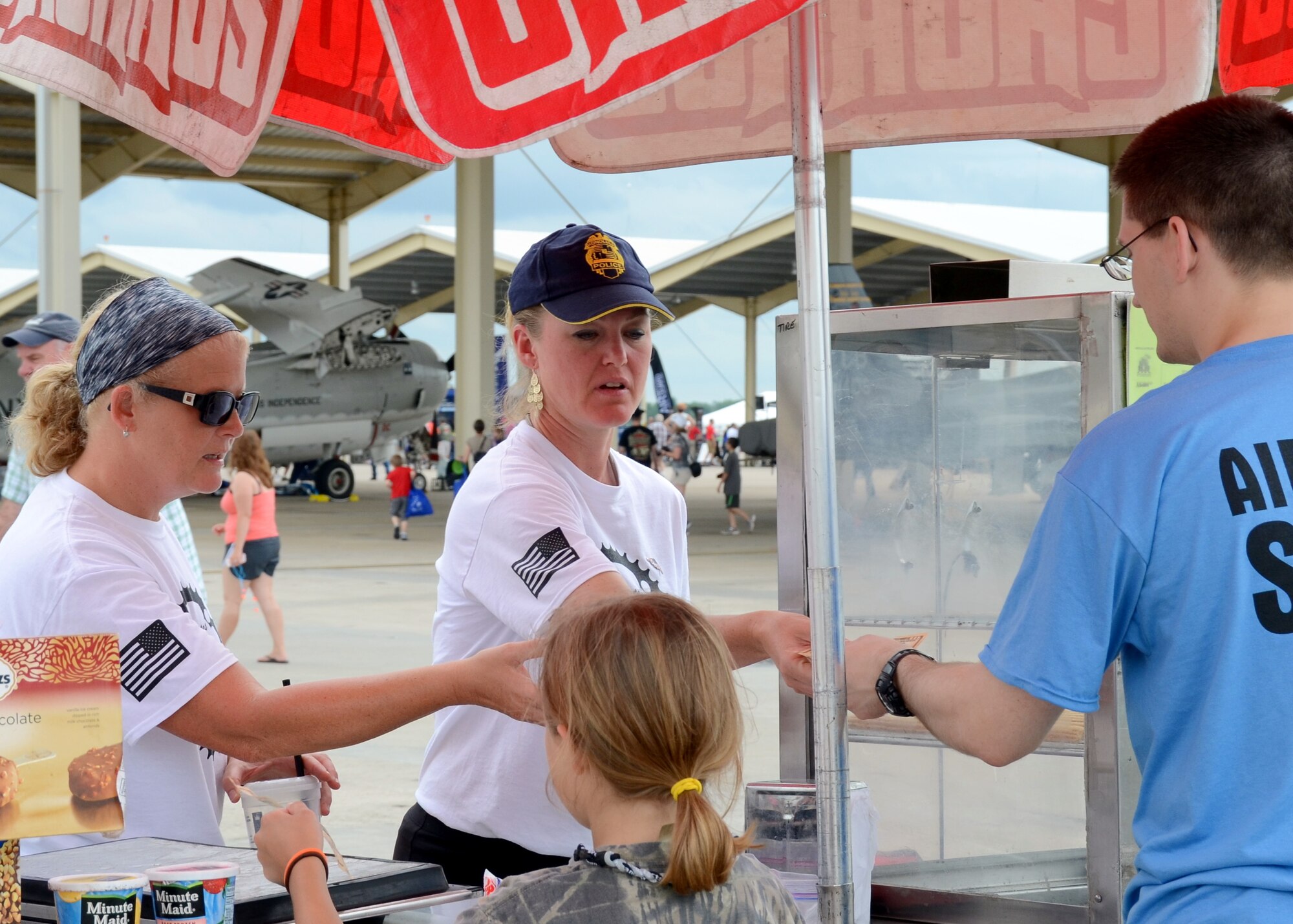 Chief Master Sgt. Barb Johnson, 131st Maintenance Operations Flight, and 1st Lt. Amy Cottrell, Medical Admin Officer with the 131st Medical Group, sell frozen treats to guests at the Wings Over Whiteman air show June 13, 2015.  The two Airmen are part of a 131st Bomb Wing/509th Bomb Wing “Total Force Integrated” bicycling team that is training and raising funds for the annual Register’s Annual Great Bicycle Ride Across Iowa (RAGBRAI), set for July 19-25, 2015.  A number of Citizen-Airmen from the Missouri Air National Guard’s 131st Bomb Wing were on hand to support the two-day air show event.  (U.S. Air National Guard photo by Airman 1st Class Halley Burgess)