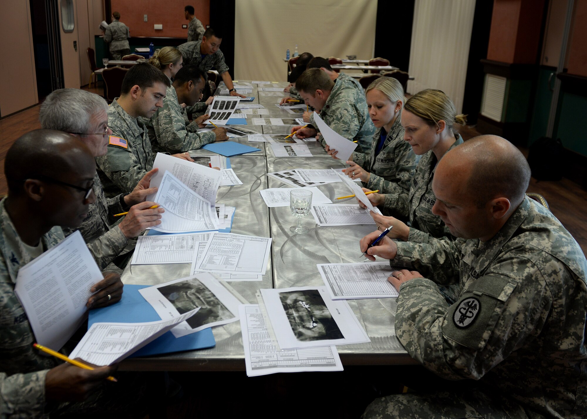 U.S. Air Force and U.S. Army dentists review oral x-rays and information sheets in order to match-up case studies during the oral education conference, June 12, 2015, at Aviano Air Base, Italy. Thirty-three people from three bases attended the symposium to complete their continued educational requirements. Aviano’s location provided a money-saving option for the conference compared to hosting the conference in the United States. (U.S. Air Force photo by Airman 1st Class Cary Smith/Released) 