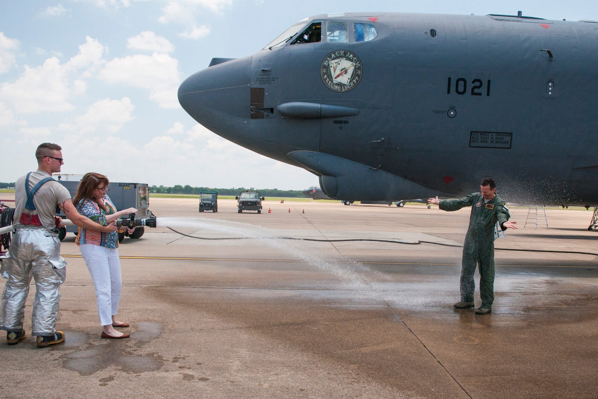 Jodie Heinz, wife of U.S. Air Force Col. Denis Heinz, 489th Bomb Group commander, fires up the water hose to spray down her husband after his return from his final mission on a B-52, June 7, 2015, Barksdale Air Force Base, La. Heinz is a B-52H Stratofortress navigator and is leaving to command the 489th Bomb Group at Dyess AFB, Texas which is assigned the B-1 Lancer. (U.S. Air Force photo by Master Sgt. Dachelle Melville/Released)