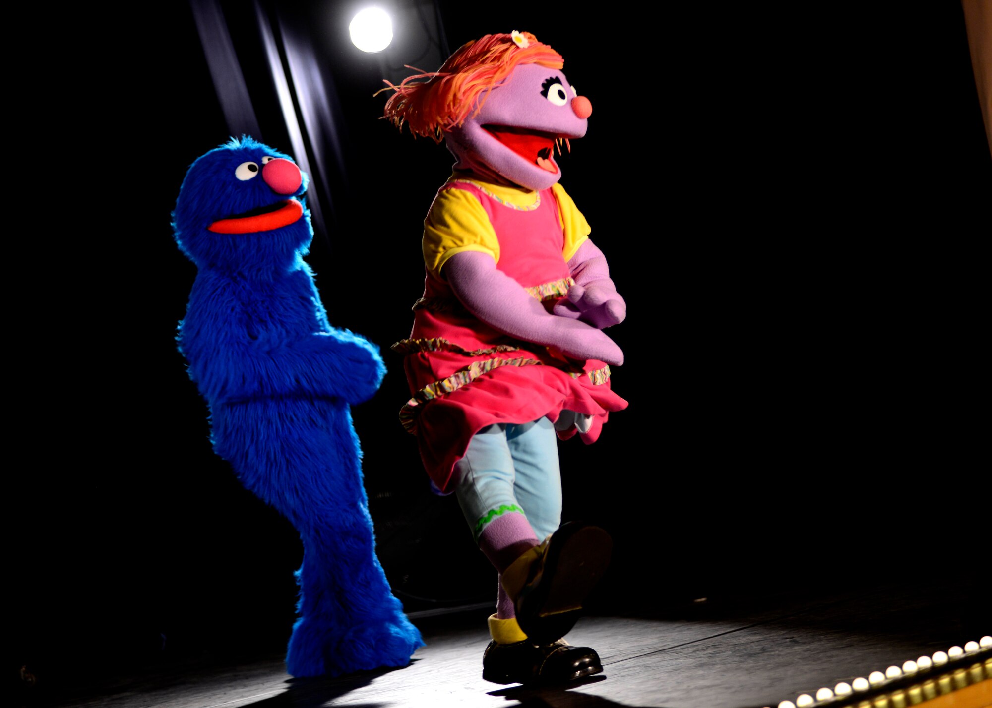 Grover and Katie perform during the Sesame Street/USO Experience for Military Families show, June 16, 2015, at Aviano Air Base, Italy. The show focused on the military child’s transition to civilian life and to a new base called “Katie’s Family Transitions to Civilian Life” and “Katie is Moving to a New Base.” The show is scheduled to perform more than 100 shows at 45 military bases in nine countries. (U.S. Air Force photo by Senior Airman Areca T. Wilson/Released) 