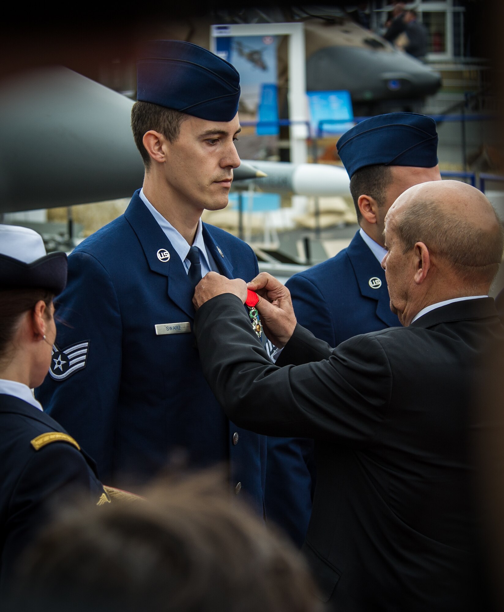 PARIS -- French Minister of Defence Jean Yves Le Drian pins the French Legion of Honor medal on Staff Sgt. Greggory Swarz at Le Bourget Airport during the International Paris Air Show, June 15, 2015. Swarz was recognized for his heroic actions on Jan. 26, 2015, when he saved the lives of three French airmen after a Hellenic air force F-16 Fighting Falcon crashed into the parking ramp at Los Llanos Air Base, Spain, during Tactical Leadership Program 15-1. Swarz is a 492nd Aircraft Maintenance Unit electrical environmental systems specialist assigned to RAF Lakenheath, U.K. (U.S. Air Force photo/ Tech. Sgt. Ryan Crane)
