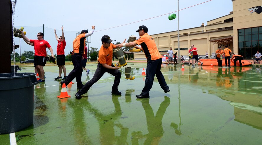 Gunsan City fire fighters participate in a bucket brigade game against Airmen from the 8th Fighter Wing during a fire muster at the Wolf Pack Fitness Center on Kunsan Air Base, Republic of Korea, June 13, 2015. Six-member teams from across Wolf Pack, the Republic of Korea Air Force and Gunsan City Fire Department competed in five events to see which teams work the best as a unit. (U.S. Air Force photo by Staff Sgt. Nick Wilson/Released)