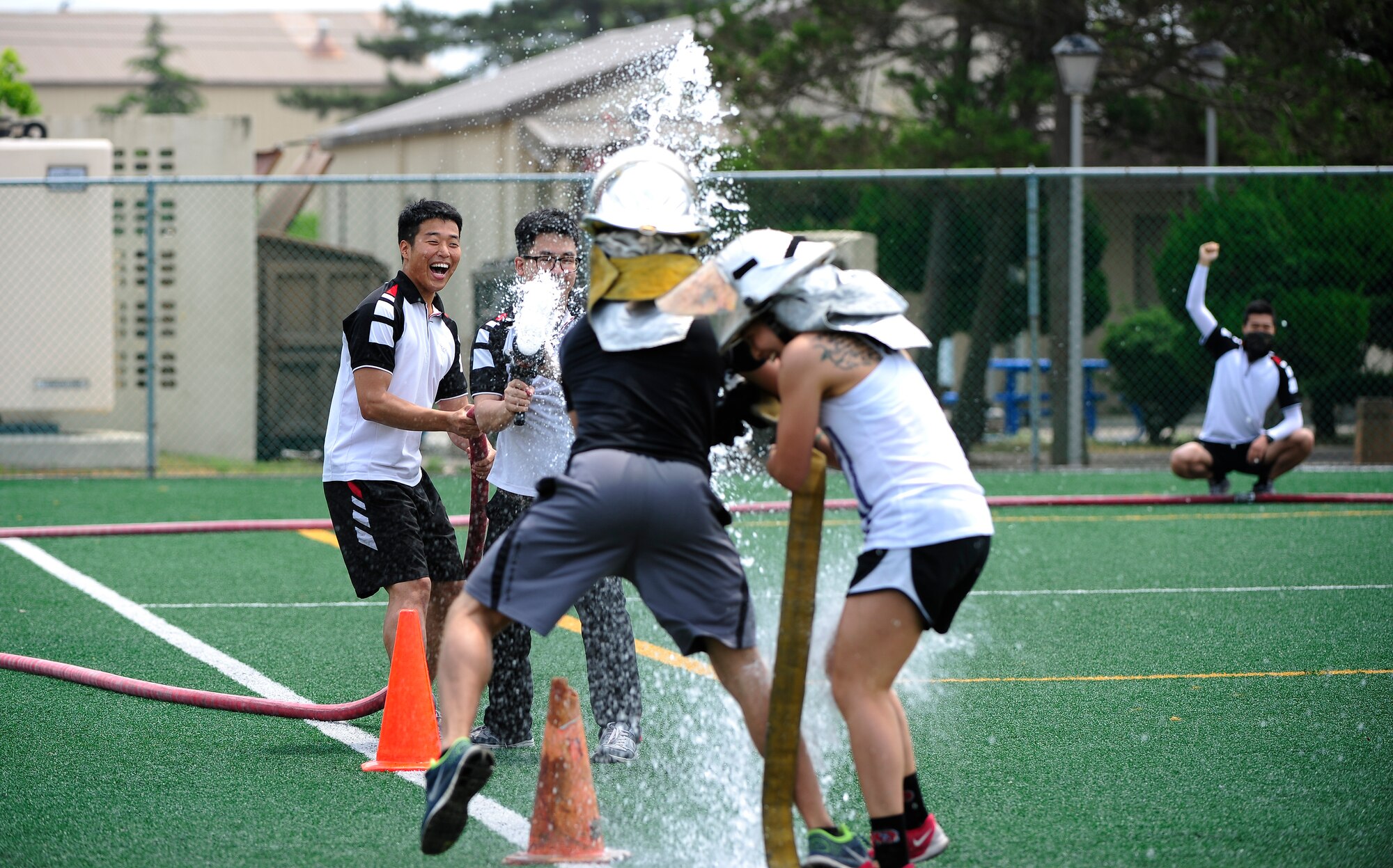 Airmen from the 8th Security Forces Squadron participate in a hose joust with Republic of Korea Air Force Airmen during a fire muster at the Wolf Pack Fitness Center on Kunsan Air Base, Republic of Korea, June 13, 2015. Six-member teams from across Wolf Pack, the Republic of Korea Air Force and Gunsan City competed in five events to see which teams work the best as a unit. (U.S. Air Force photo by Staff Sgt. Nick Wilson/Released)