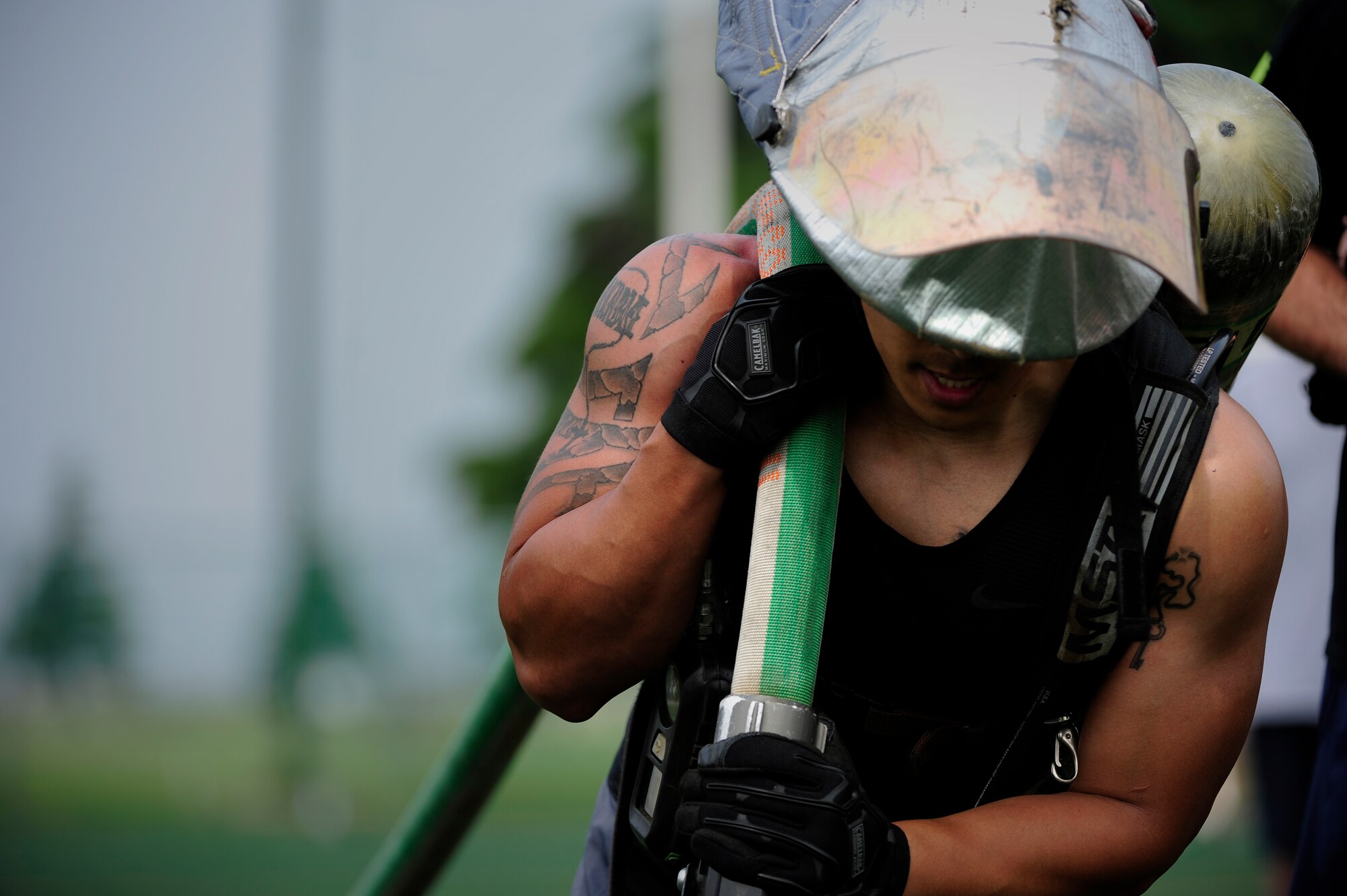 Tech. Sgt. Chris Galbadores, 8th Security Forces Squadron NCO in charge of combat arms, completes the final stretch of a 100-foot charged hose line pull during a fire muster at the Wolf Pack Fitness Center on Kunsan Air Base, Republic of Korea, June 13, 2015. The individual portion of the event consisted of a 10-stage firefighter training circuit, which Airmen had eight minutes to complete. (U.S. Air Force photo by Staff Sgt. Nick Wilson/Released)