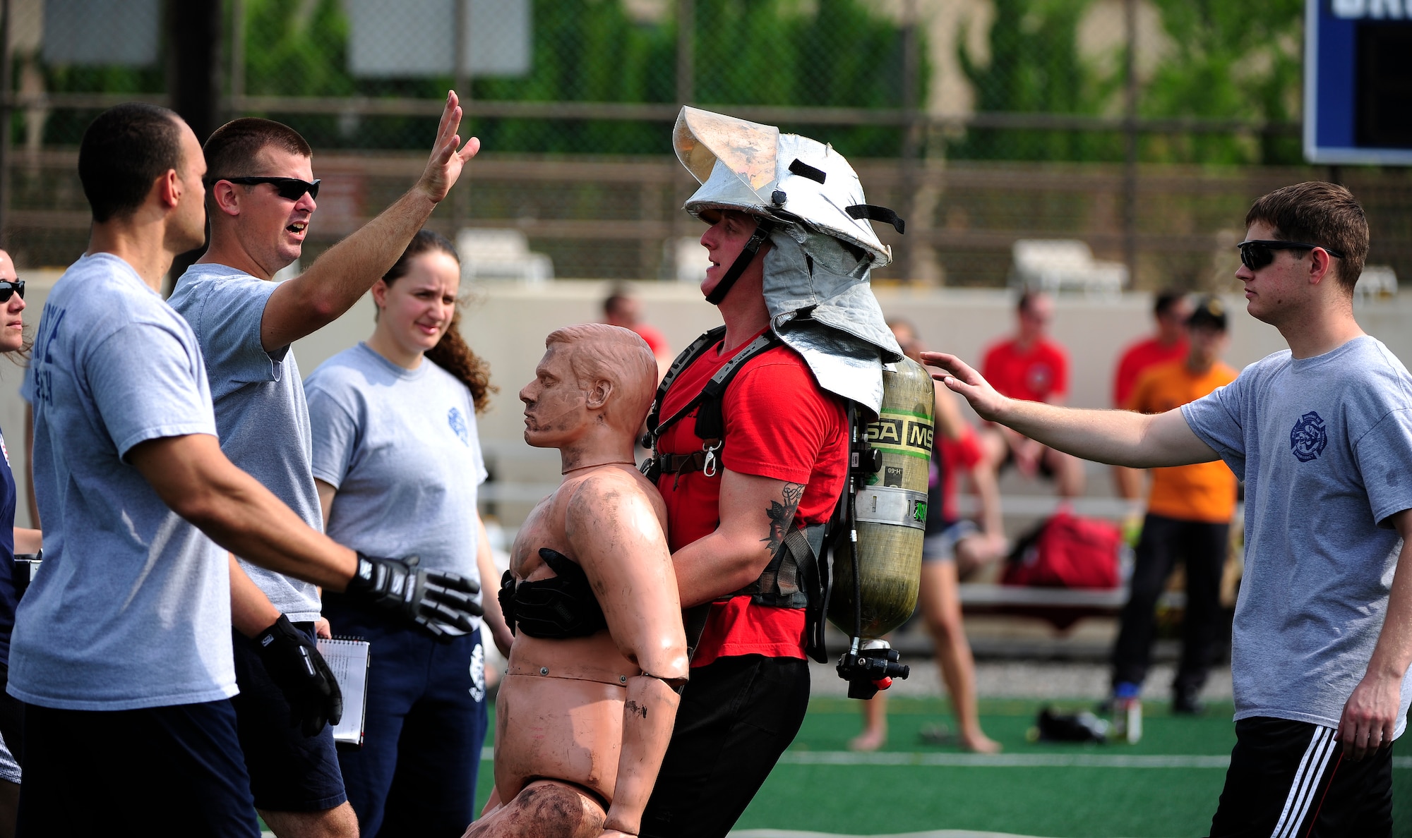 Trainers assist a firefighter from the 8th Civil Engineer Squadron as he participates in a 150-pound dummy drag during a fire muster at the Wolf Pack Fitness Center on Kunsan Air Base, Republic of Korea, June 13, 2015. The fire muster gave Airmen from all over the wing an opportunity to test their fitness abilities against one another. (U.S. Air Force photo by Staff Sgt. Nick Wilson/Released)