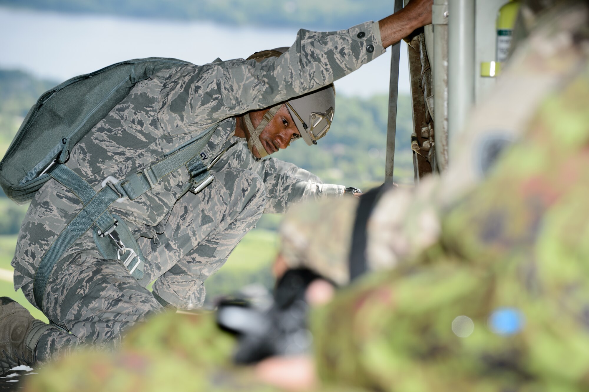 Tech. Sgt. Cameron Riley, 435th Contingency Response Group jumpmaster, looks out the back of a C-130J Super Hercules prior to parachuting out June 15, 2015, Lielvarde Air Base, Latvia. More than 70 U.S. Air Force, U.S. Army and Latvian service members participated in a jump day to strengthen the bonds of allies and learn from each other during exercise Saber Strike 15. The exercise involves more than 6,000 service members from 14 nations participation all throughout Estonia, Latvia, Lithuania, and Poland to learn from each other and promote stability is the region. (U.S. Air Force photo/ Staff Sgt. Armando A. Schwier-Morales)