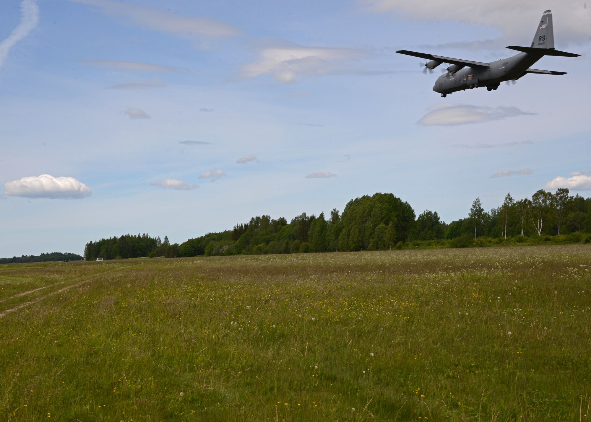 A C-130J Hercules aircraft assigned to the 37th Airlift Squadron, Ramstein Air Base, Germany, flies over an airfield in Nurmsi, Estonia during Saber Strike 15, June 11, 2015. The aircraft was used to insert a Contingency Response Group onto the airfield to assess the area for suitability as a landing strip for follow on aircraft. (Air National Guard photo/ Tech. Sgt. Christopher Schepers)