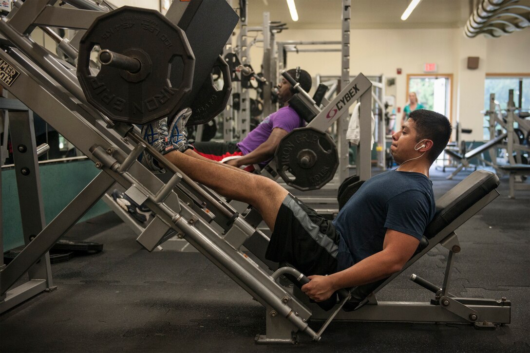 Senior Airman George Gonzales, 8th Maintenance Squadron electronics warfare technician, leg presses 200 pounds at the Kunsan Fitness Center, Republic of Korea, June 12, 2015. The 8th Medical Operations Squadron health promotions office offers strength training 101, a class that teaches Airmen the basics of incorporating effective strength training exercises in their personal fitness program. (U.S. Air Force photo by Senior Airman Katrina Heikkinen/Released)