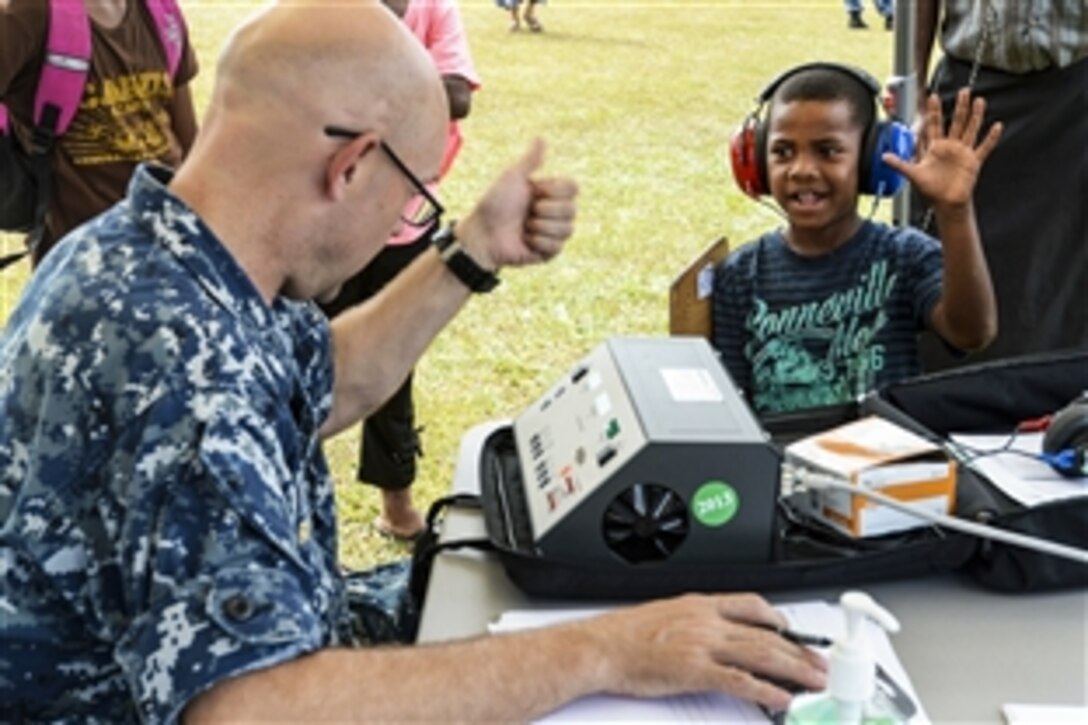 U.S. Navy Cmdr. Alan Ross performs a hearing test on a Fijian boy during Pacific Partnership 2015 in Seaqaqa, Fiji, June 13, 2015. The Military Sealift Command hospital ship USNS Mercy is in Savusavu, Fiji, for the annual humanitarian assistance and disaster relief preparedness mission.