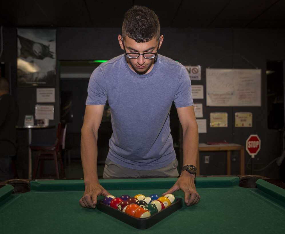 Marine Corps Communication-Electronics School student racks billiard balls before match during Single Marine Program’s weekly pool tournament held at 5th Street Zone, Twentynine Palms, California, July 16, 2015 (U.S. Marine Corps/Levi Schultz)